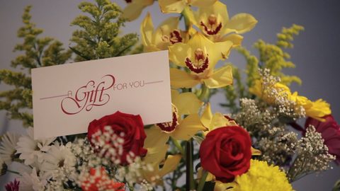 A Berenice gift certificate card beside a bouquet of flowers