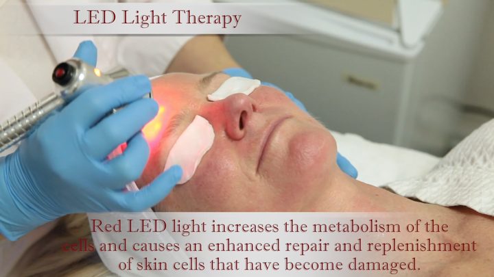 A practitioner at Berenice applying red LED light therapy to a client's face