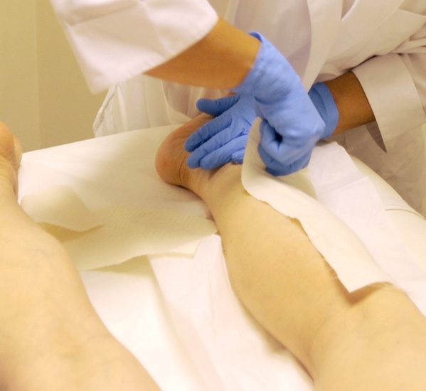 A practitioner at Berenice working a wax strip on a client's leg